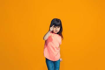 Image showing The happy teen girl pointing to you, half length closeup portrait on orange background.