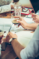 Image showing The hands of people working and relaxing in pub.