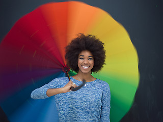 Image showing african american woman holding a colorful umbrella