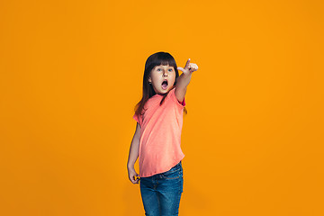 Image showing Beautiful teen girl looking suprised isolated on orange