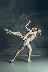 Image showing The young modern ballet dancers posing on gray studio background