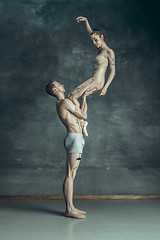 Image showing The young modern ballet dancers posing on gray studio background