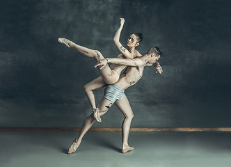 Image showing The young modern ballet dancers posing on gray studio background