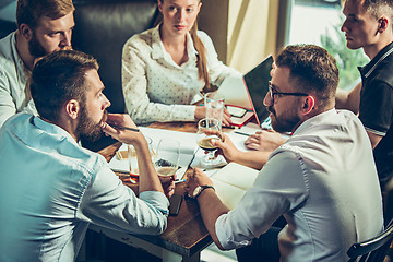 Image showing Young cheerful people smile and gesture while relaxing in pub.