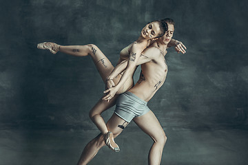 Image showing The young modern ballet dancers posing on gray studio background