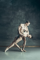 Image showing The young modern ballet dancers posing on gray studio background