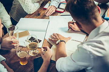 Image showing Young cheerful people smile and gesture while relaxing in pub.