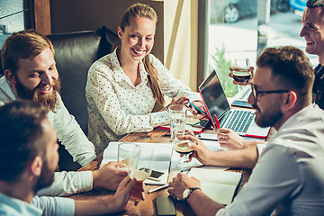 Image showing Young cheerful people smile and gesture while relaxing in pub.