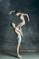 Image showing The young modern ballet dancers posing on gray studio background