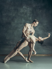 Image showing The young modern ballet dancers posing on gray studio background