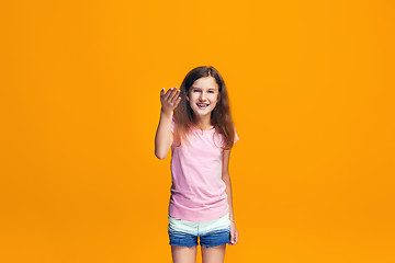 Image showing Beautiful teen girl looking suprised isolated on orange