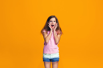 Image showing Beautiful teen girl looking suprised isolated on orange