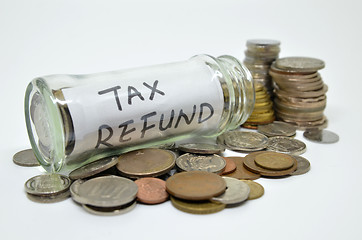 Image showing Tax refund lable in a glass jar with coins spilling out