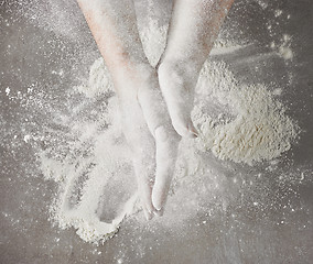 Image showing bakers hands with flour in motion