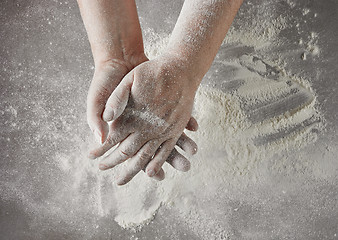 Image showing baker hands with flour in motion