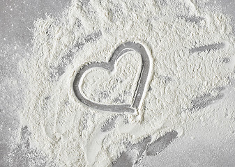 Image showing heart shape in flour on grey kitchen table