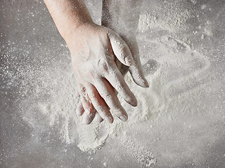 Image showing baker hands with flour in motion