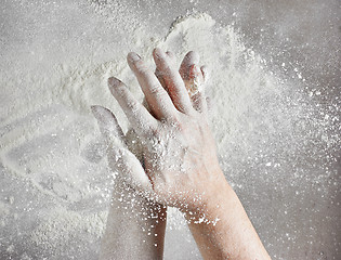 Image showing baker hands with flour in motion