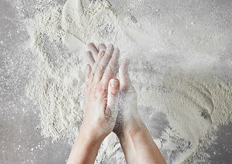 Image showing baker hands with flour in motion