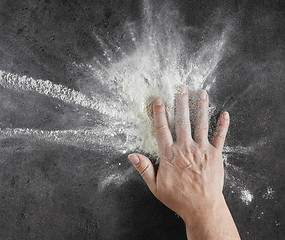 Image showing bakers hand with flour in motion