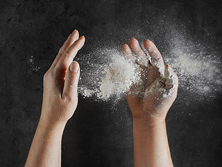 Image showing baker hands with flour in motion