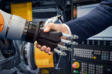 Image showing Hand of a businessman shaking hands with a Android robot.