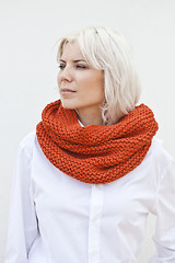 Image showing Woman in warm orange wool knitted snood scarf.