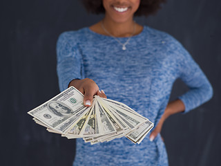 Image showing black woman holding money on gray background