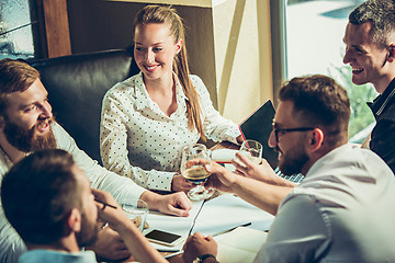 Image showing Young cheerful people smile and gesture while relaxing in pub.