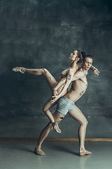 Image showing The young modern ballet dancers posing on gray studio background