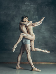 Image showing The young modern ballet dancers posing on gray studio background