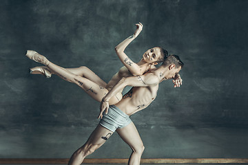 Image showing The young modern ballet dancers posing on gray studio background