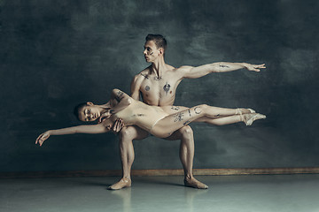 Image showing The young modern ballet dancers posing on gray studio background