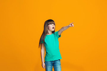 Image showing Beautiful teen girl looking suprised isolated on orange