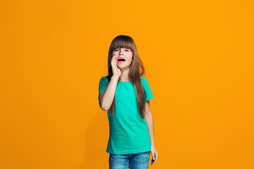 Image showing Isolated on yellow young casual teen girl shouting at studio