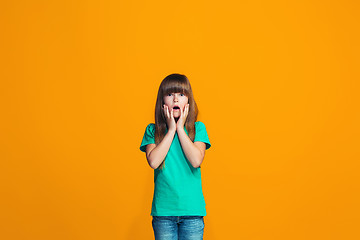 Image showing Beautiful teen girl looking suprised isolated on orange