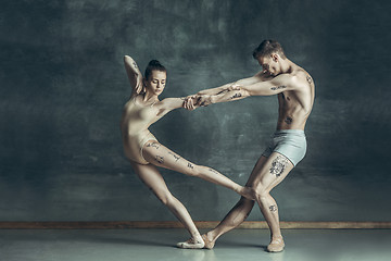 Image showing The young modern ballet dancers posing on gray studio background