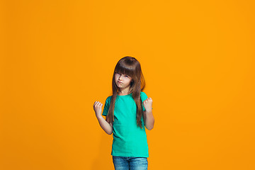 Image showing Portrait of angry teen girl on a orange studio background