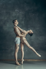 Image showing The young modern ballet dancers posing on gray studio background