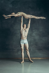 Image showing The young modern ballet dancers posing on gray studio background