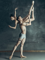 Image showing The young modern ballet dancers posing on gray studio background