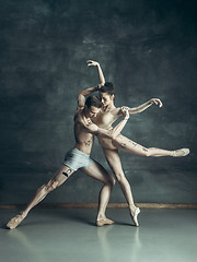 Image showing The young modern ballet dancers posing on gray studio background