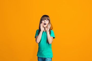 Image showing Isolated on yellow young casual teen girl shouting at studio