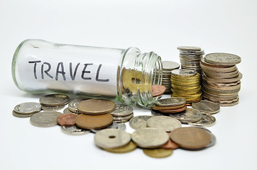 Image showing Travel lable in a glass jar with coins spilling out