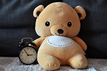 Image showing Cute teddy bear hold alarm clock