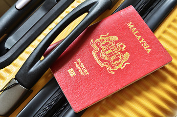 Image showing Malaysia passport on a yellow suitcase