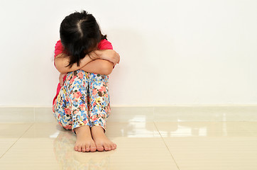Image showing Sad little girl sit on the floor.