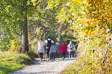 Image showing Group of people walking by hiking trail in the autumn forest