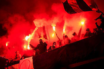 Image showing football hooligans with mask holding torches in fire