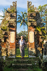 Image showing Young blonde caucasian woman traveling and exploring traditional hidu tamples around Ubud on Bali.